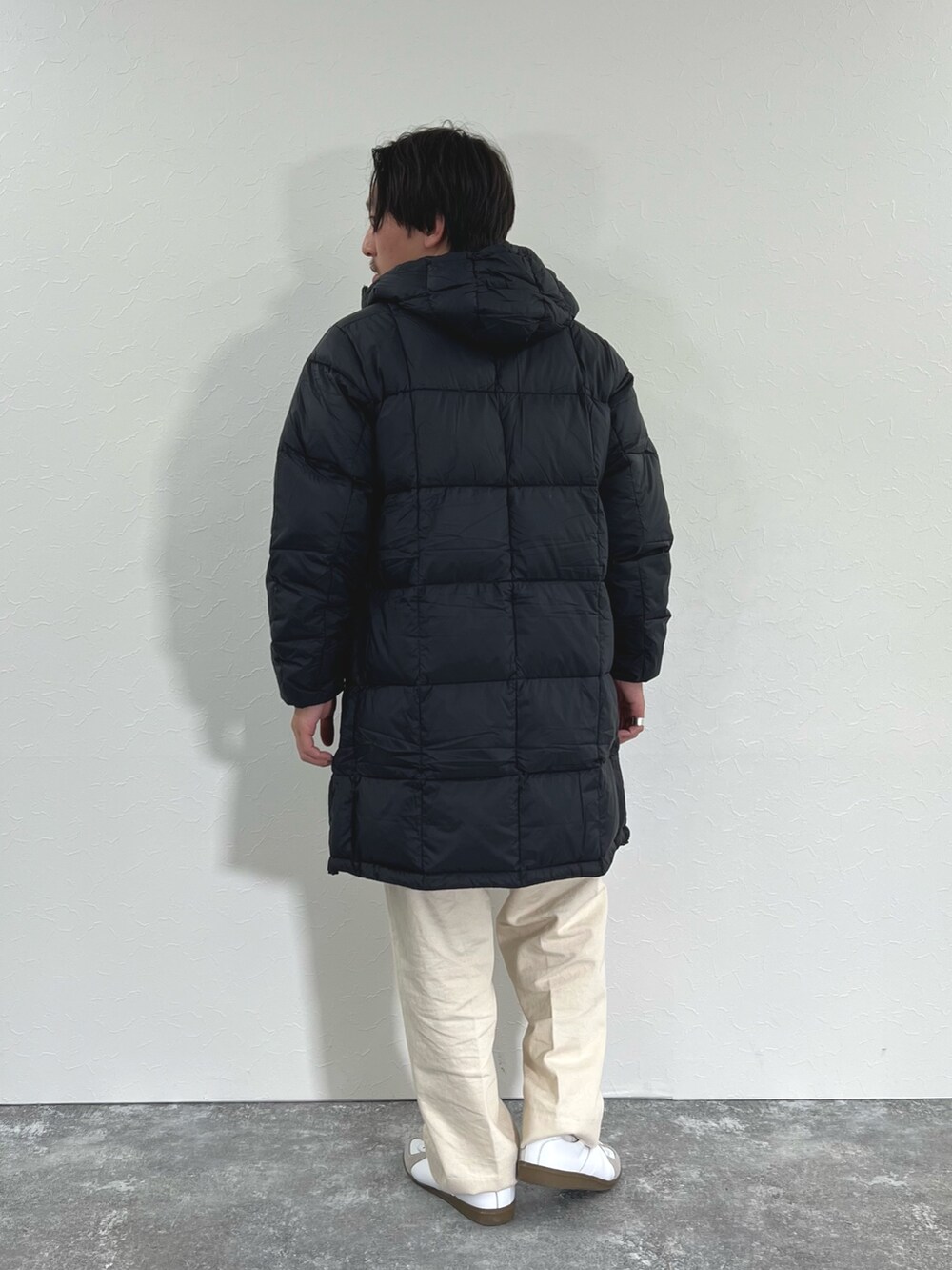 ブラック系のダウンジャケット/コート、ホワイト系のカーディガン/ボレロ、ホワイト系のTシャツ/カットソーを着用したメンズの冬コーディネートの7枚目の写真