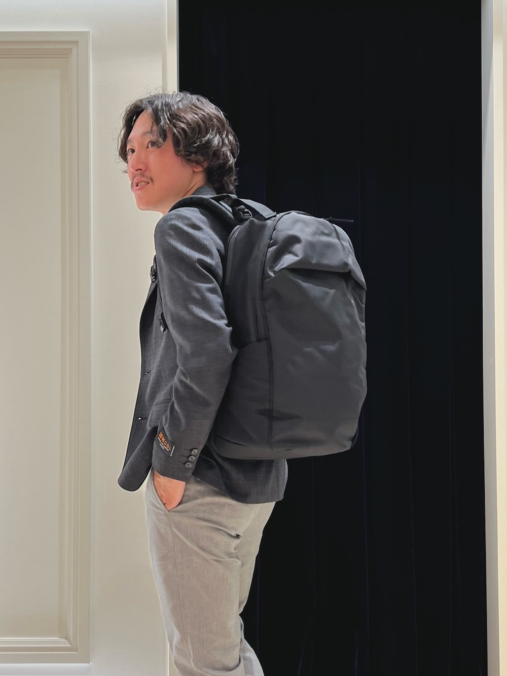 グレー系のテーラードジャケット、ホワイト系のTシャツ/カットソー、グレー系のチノパンツを着用したメンズの春コーディネートの4枚目の写真