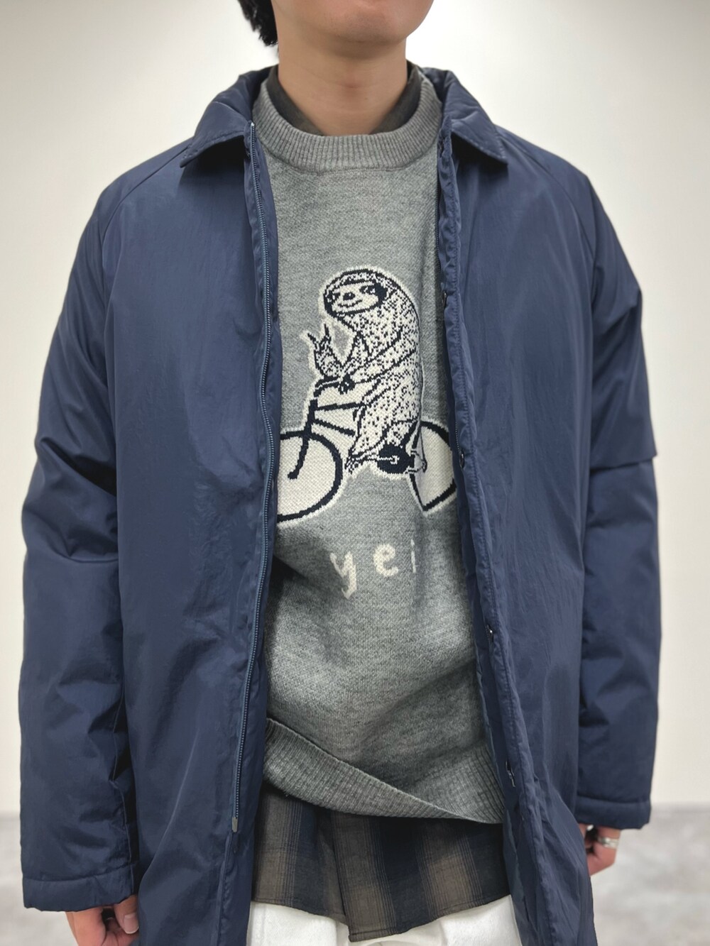 ブルー系のダウンジャケット/コート、グレー系のニット/セーター、グリーン系のシャツ/ブラウスを着用したメンズの冬コーディネートの7枚目の写真