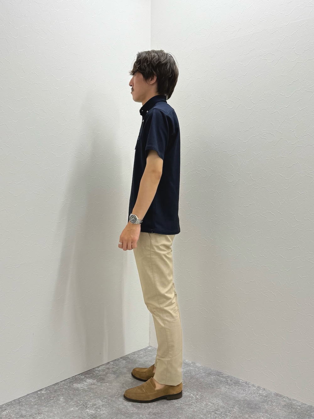 ブルー系のポロシャツ、ベージュ系のチノパンツ、イエロー系のローファーを着用したメンズの夏コーディネートの3枚目の写真