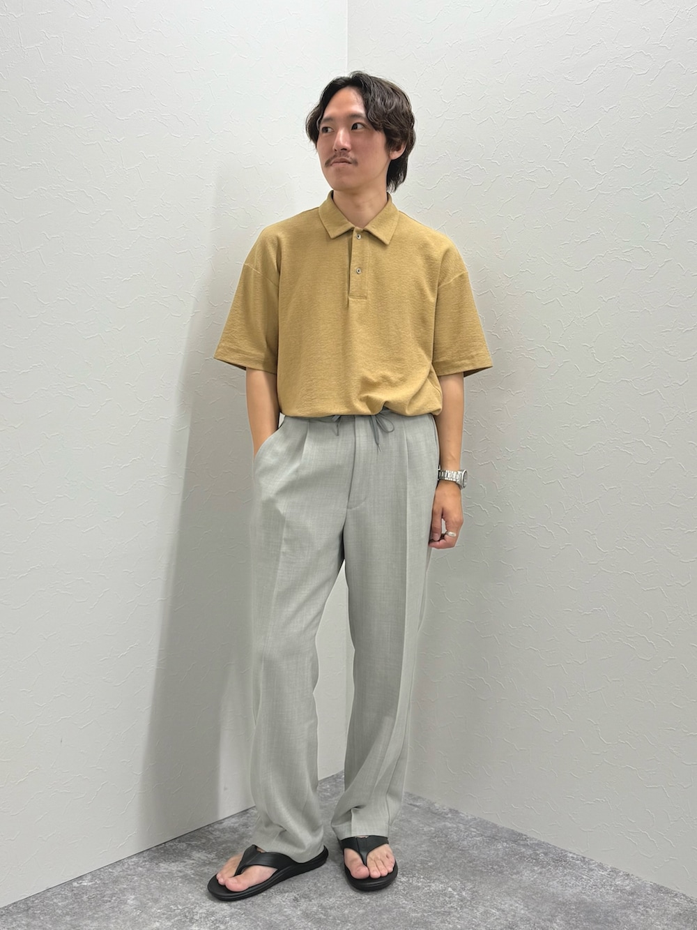 ベージュ系のポロシャツ、ブラック系のサンダルを着用したメンズの夏コーディネートの5枚目の写真