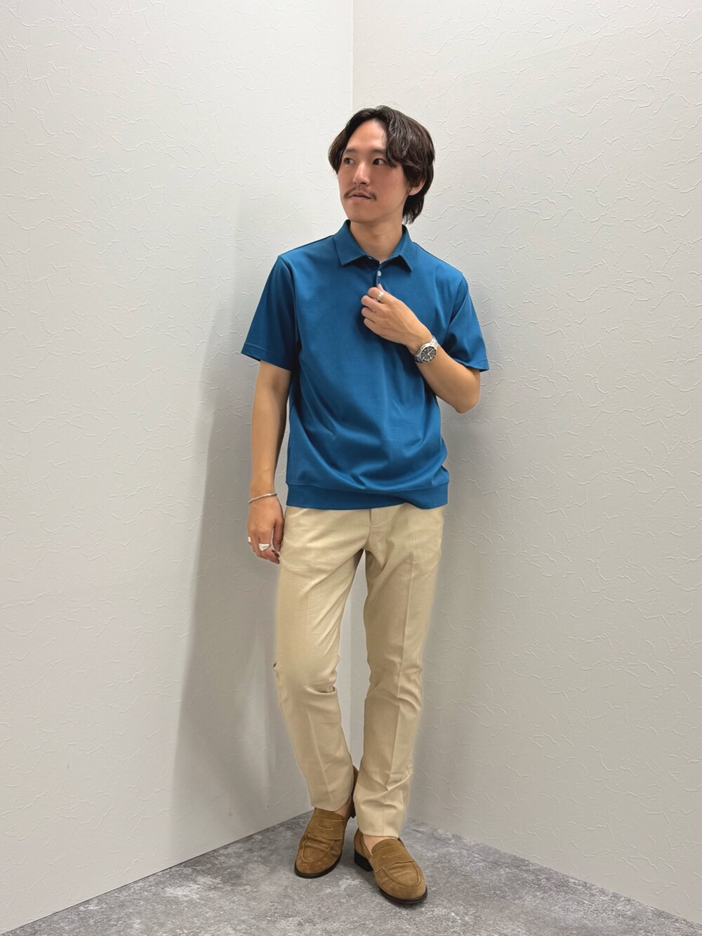 ブルー系のポロシャツ、ベージュ系のチノパンツ、ブルー系のテーラードジャケットを着用したメンズの夏コーディネートの2枚目の写真