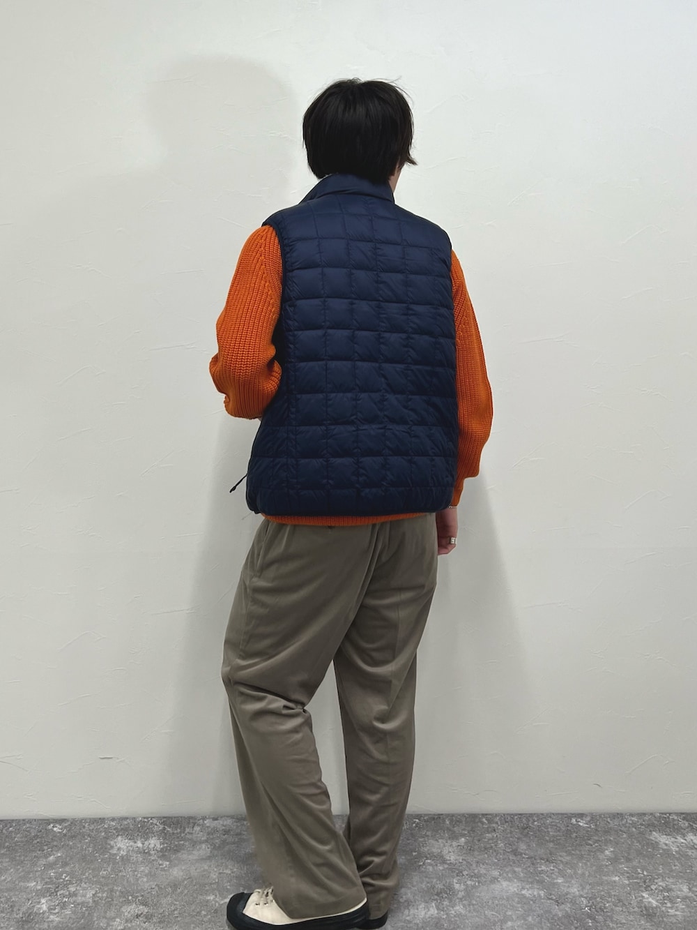 ホワイト系のダウンベスト、ベージュ系のその他パンツを着用したメンズの秋コーディネートの7枚目の写真