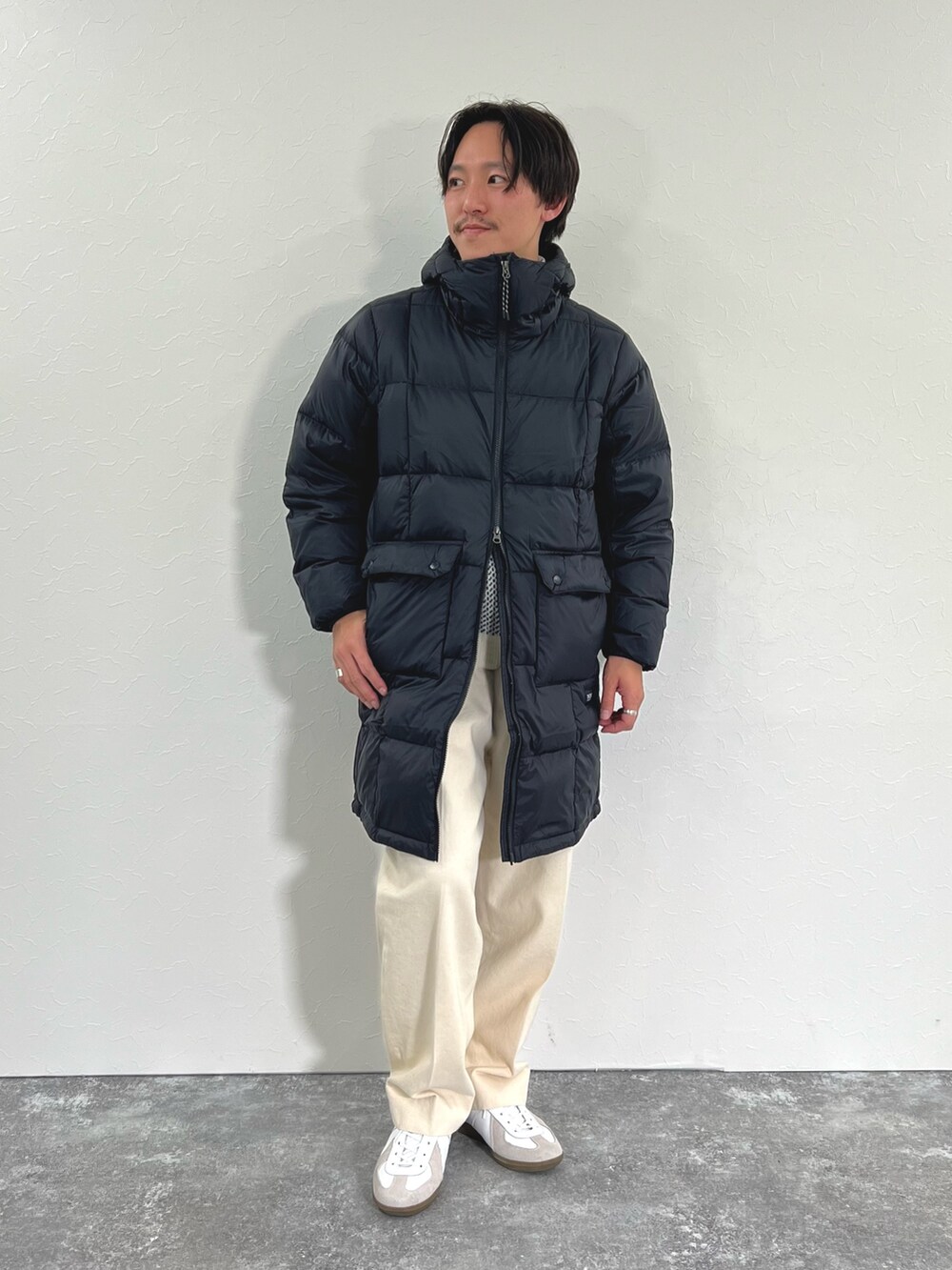 ブラック系のダウンジャケット/コート、ホワイト系のカーディガン/ボレロ、ホワイト系のTシャツ/カットソーを着用したメンズの冬コーディネートの3枚目の写真