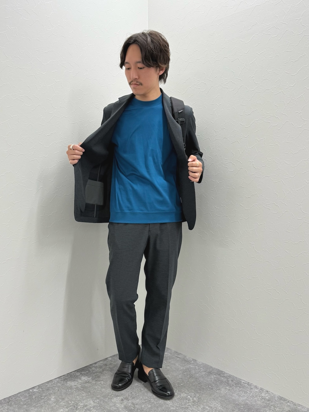 ブラック系のバックパック/リュック、ブラック系のローファー、ブルー系のTシャツ/カットソーを着用したメンズの夏コーディネートの4枚目の写真