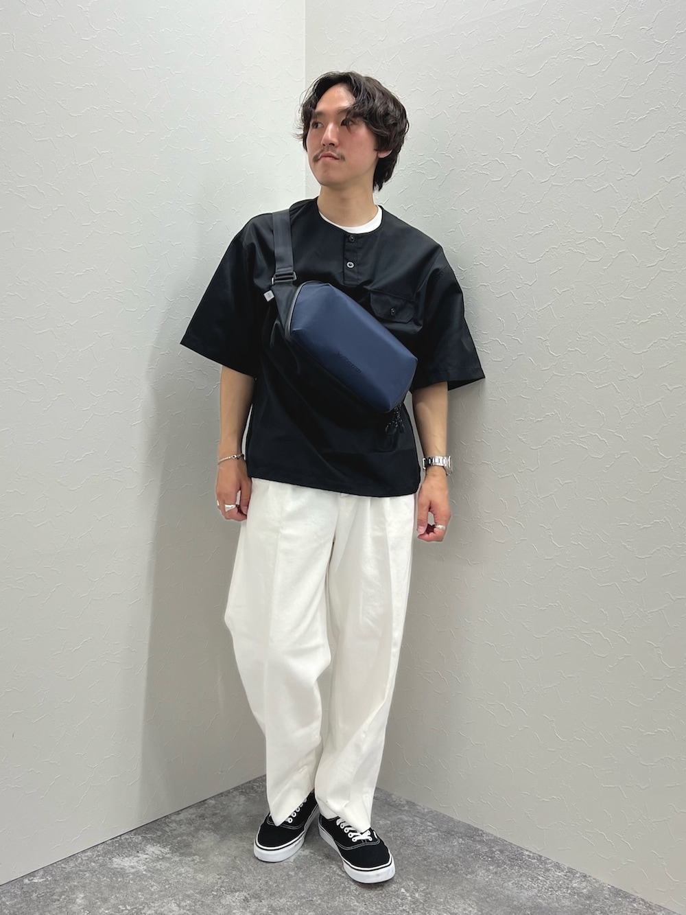 ブラック系のTシャツ/カットソー、ブルー系のショルダーバッグ、ホワイト系のデニムパンツを着用したメンズの春コーディネートの3枚目の写真
