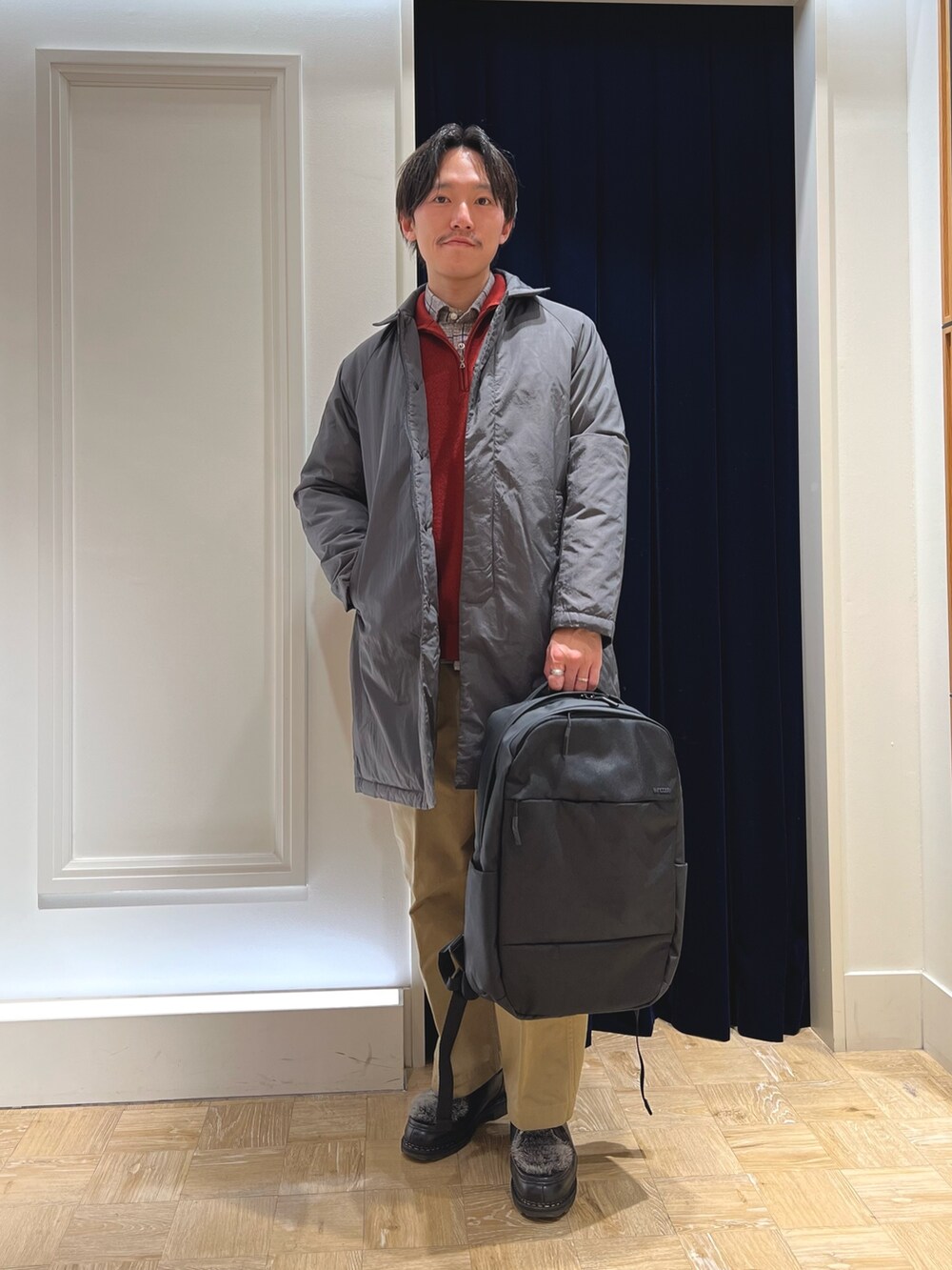 グレー系のダウンジャケット/コート、ブラック系のシャツ/ブラウス、レッド系のニット/セーターを着用したメンズの冬コーディネートの2枚目の写真