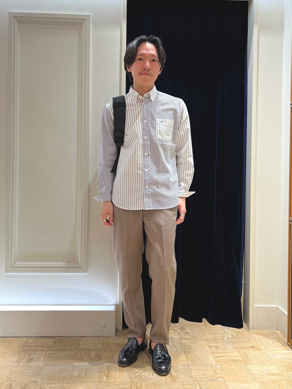 ホワイト系のシャツ/ブラウス、ベージュ系のその他パンツ、ブラック系のバックパック/リュックを着用したメンズの冬コーディネートの2枚目の写真