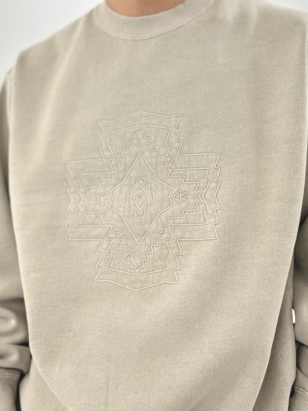 ベージュ系のスウェット、ブラック系のスニーカーを着用したメンズの秋コーディネートの6枚目の写真