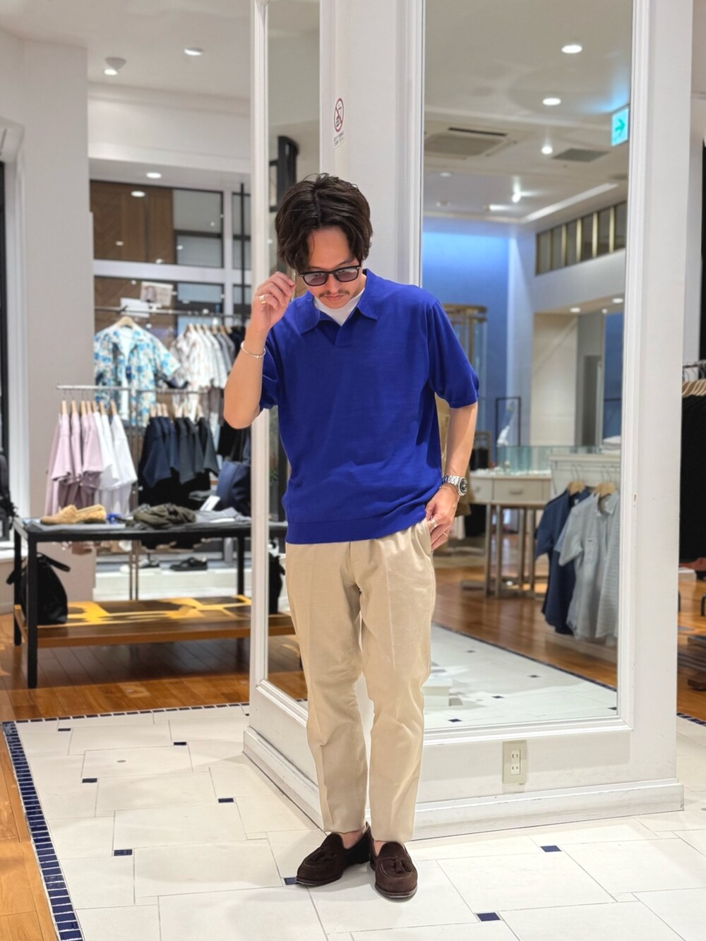 ブルー系のポロシャツ、ベージュ系のその他パンツ、ブラウン系のローファーを着用したメンズの春コーディネートの4枚目の写真