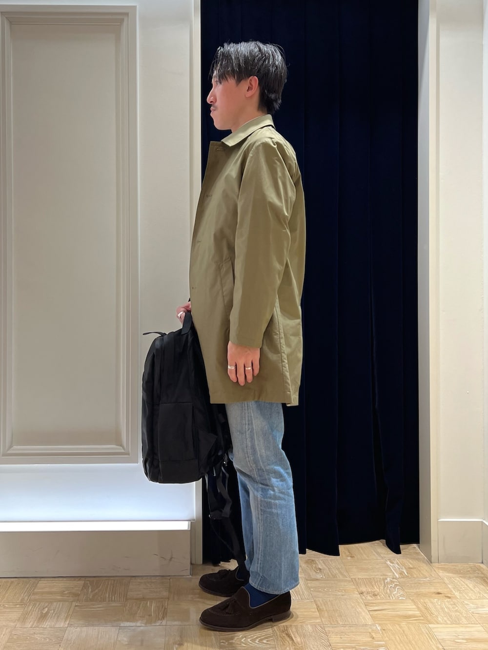 ベージュ系のシャツ/ブラウス、グリーン系のステンカラーコート、ブラック系のバックパック/リュックを着用したメンズの冬コーディネートの3枚目の写真