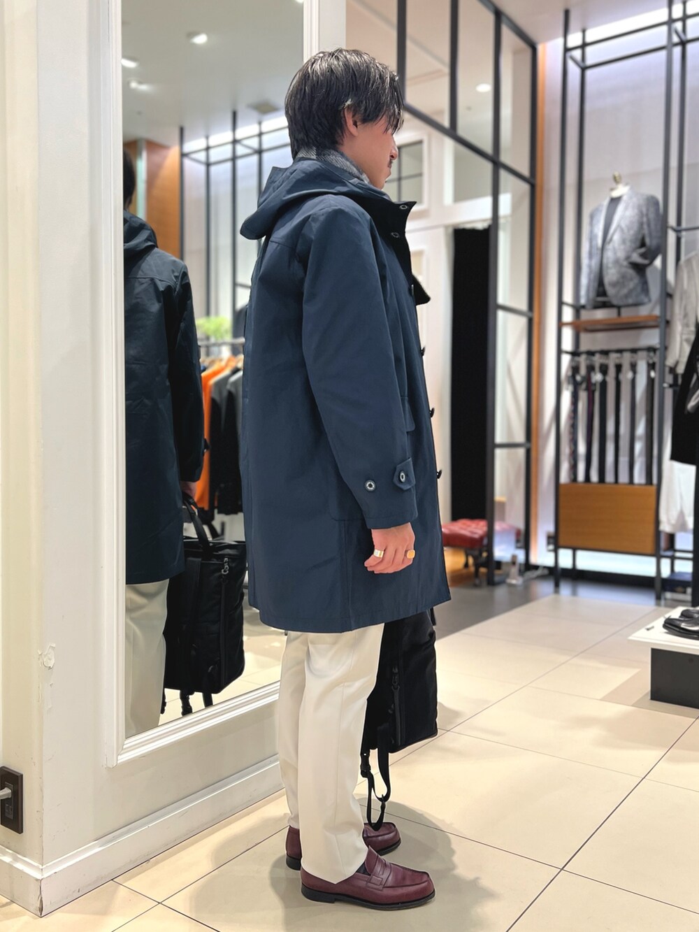 ブルー系のその他アウター、ブルー系のニット/セーター、ブラック系のトートバッグを着用したメンズの冬コーディネートの6枚目の写真