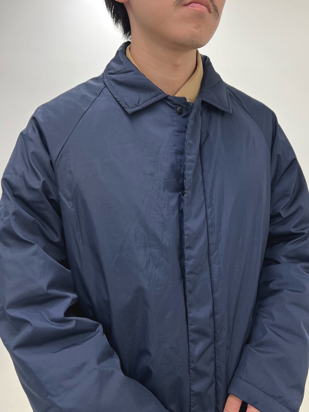 グレー系のその他パンツ、ブルー系のダウンジャケット/コート、ホワイト系のTシャツ/カットソーを着用したメンズの秋コーディネートの7枚目の写真