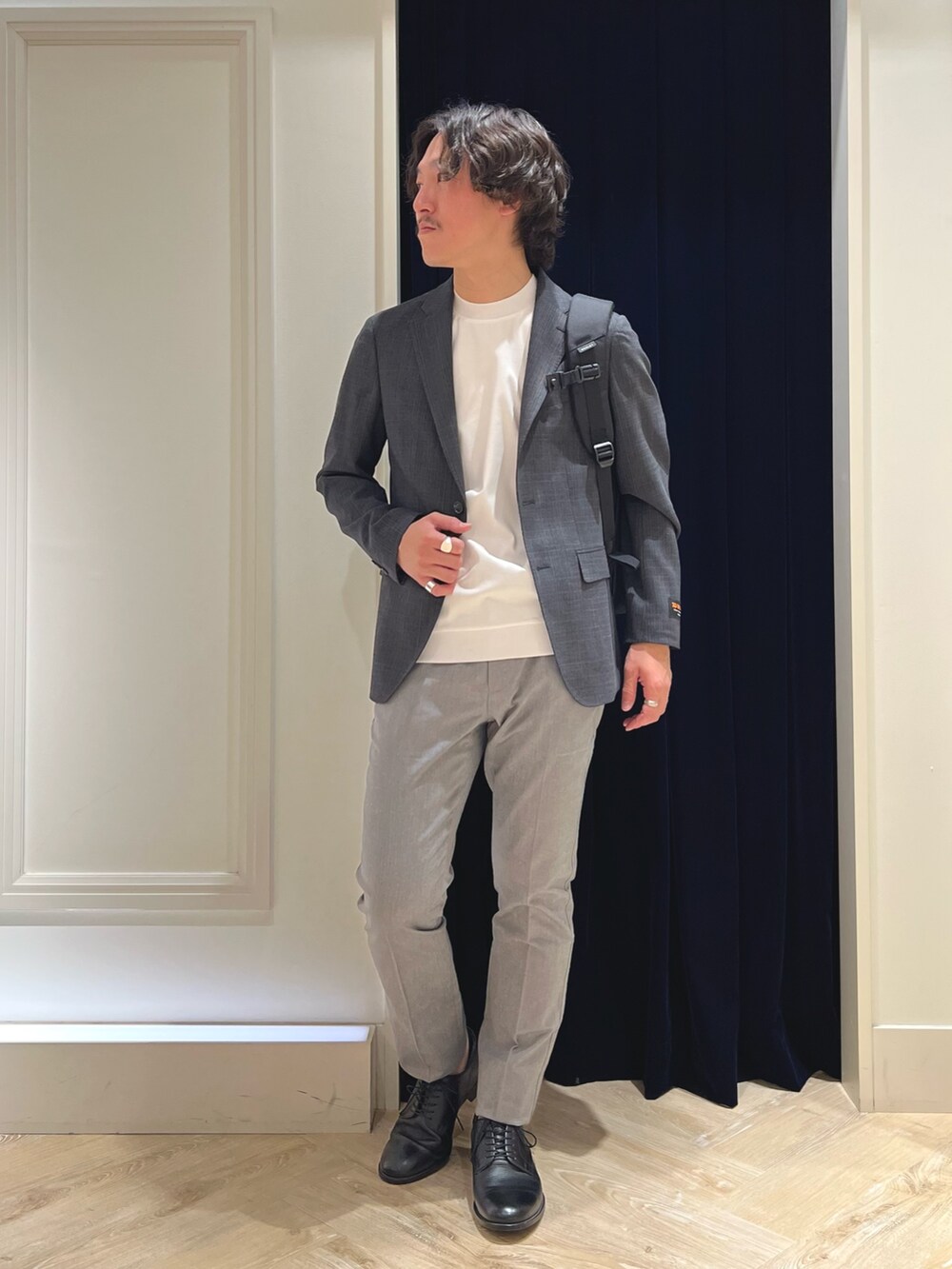 グレー系のテーラードジャケット、ホワイト系のTシャツ/カットソー、グレー系のチノパンツを着用したメンズの春コーディネートの2枚目の写真