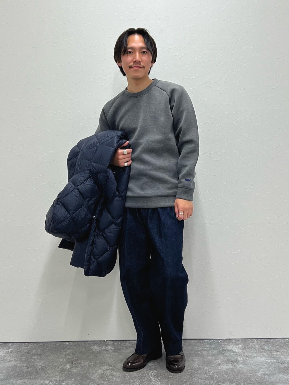 ブルー系のダウンジャケット/コート、グレー系のスウェット、ブルー系のデニムパンツを着用したメンズの冬コーディネートの5枚目の写真