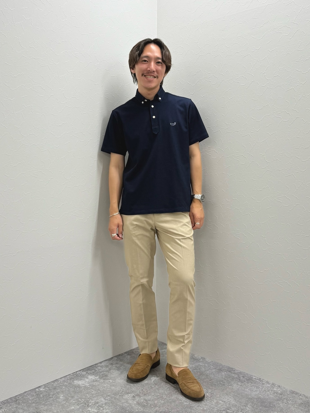 ブルー系のポロシャツ、ベージュ系のチノパンツ、イエロー系のローファーを着用したメンズの夏コーディネートの2枚目の写真
