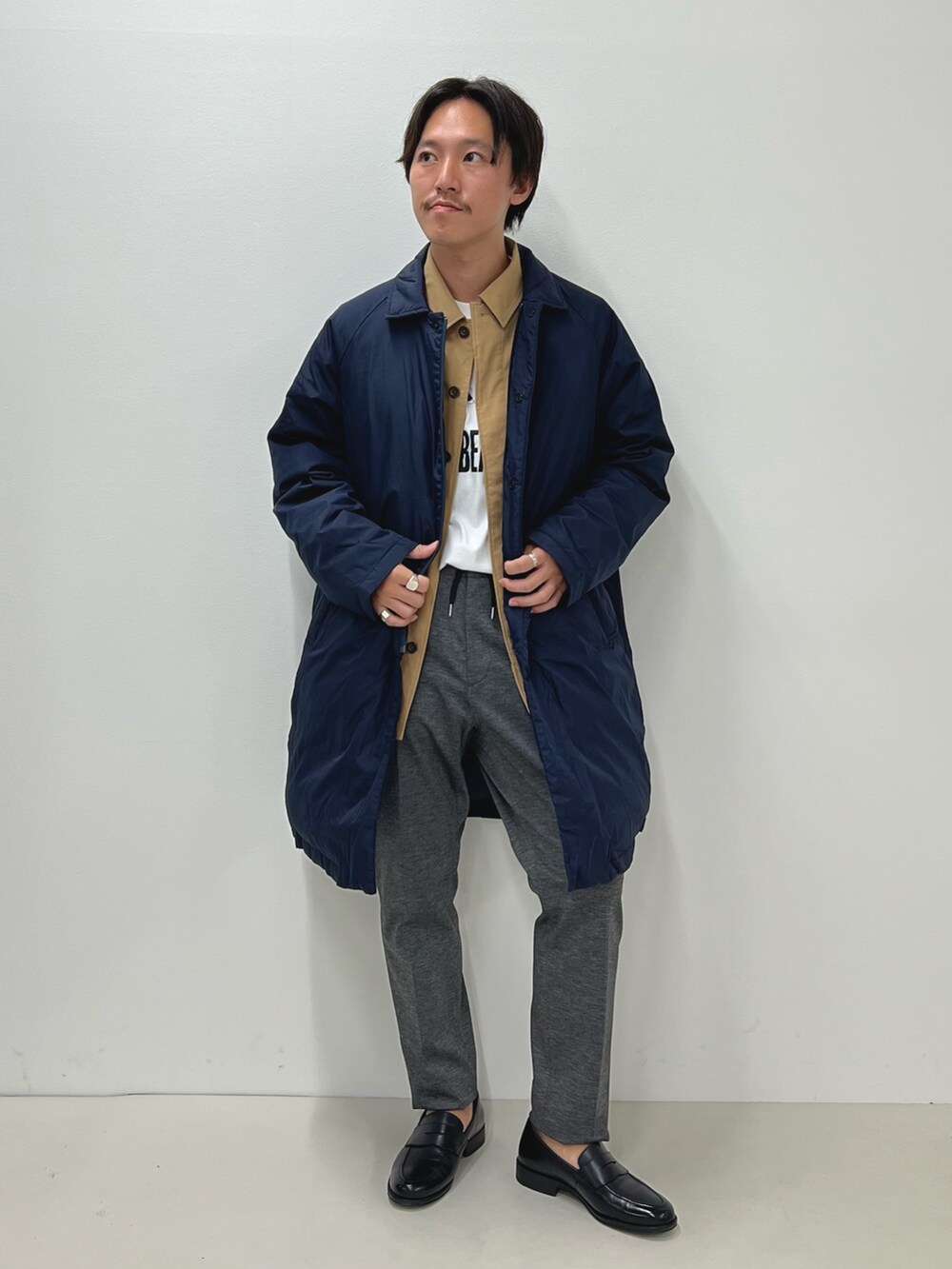 グレー系のその他パンツ、ブルー系のダウンジャケット/コート、ホワイト系のTシャツ/カットソーを着用したメンズの秋コーディネートの4枚目の写真