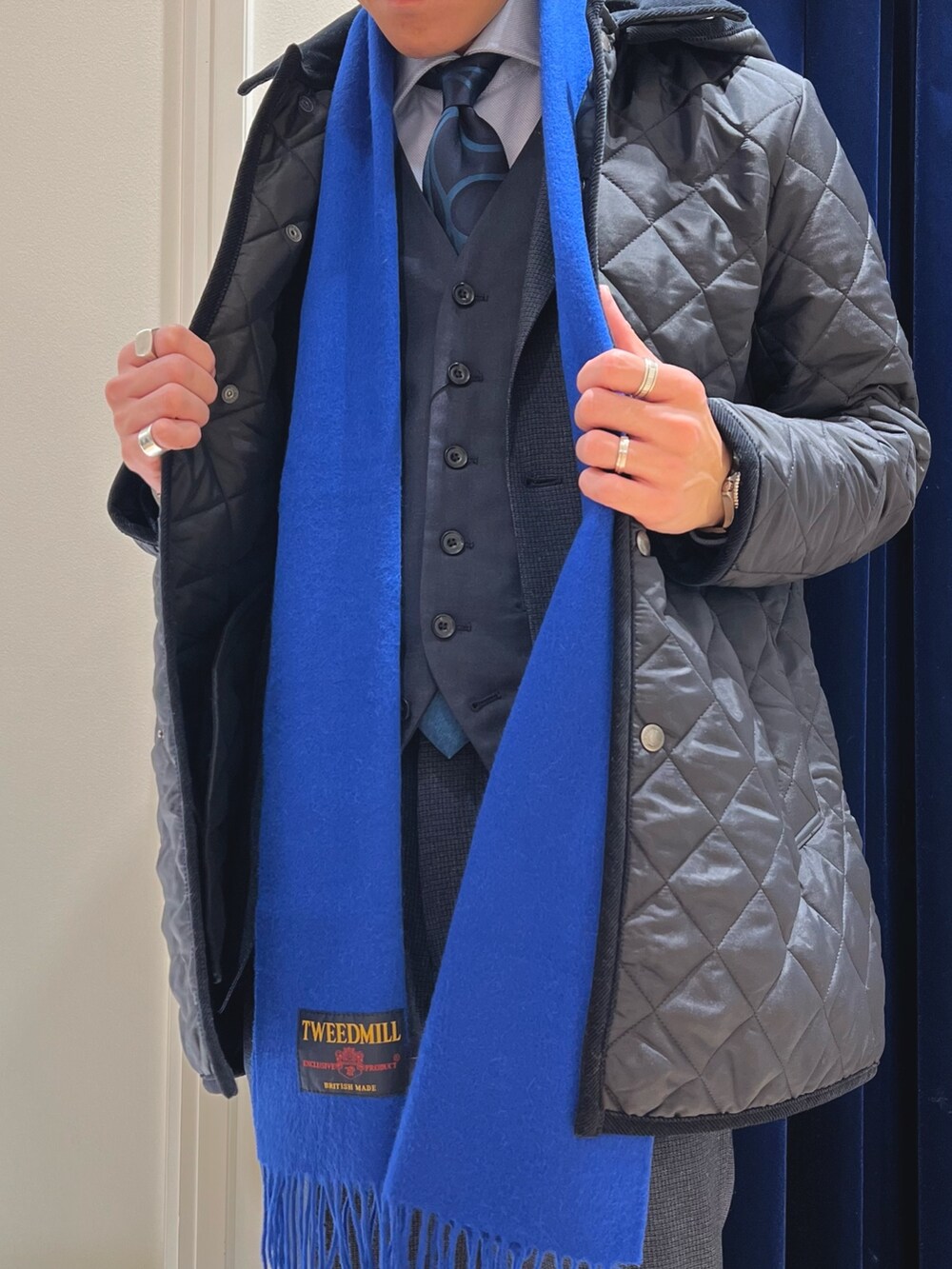 ブルー系のスラックス、ブラック系のローファー、ブルー系のネクタイを着用したメンズの冬コーディネートの6枚目の写真