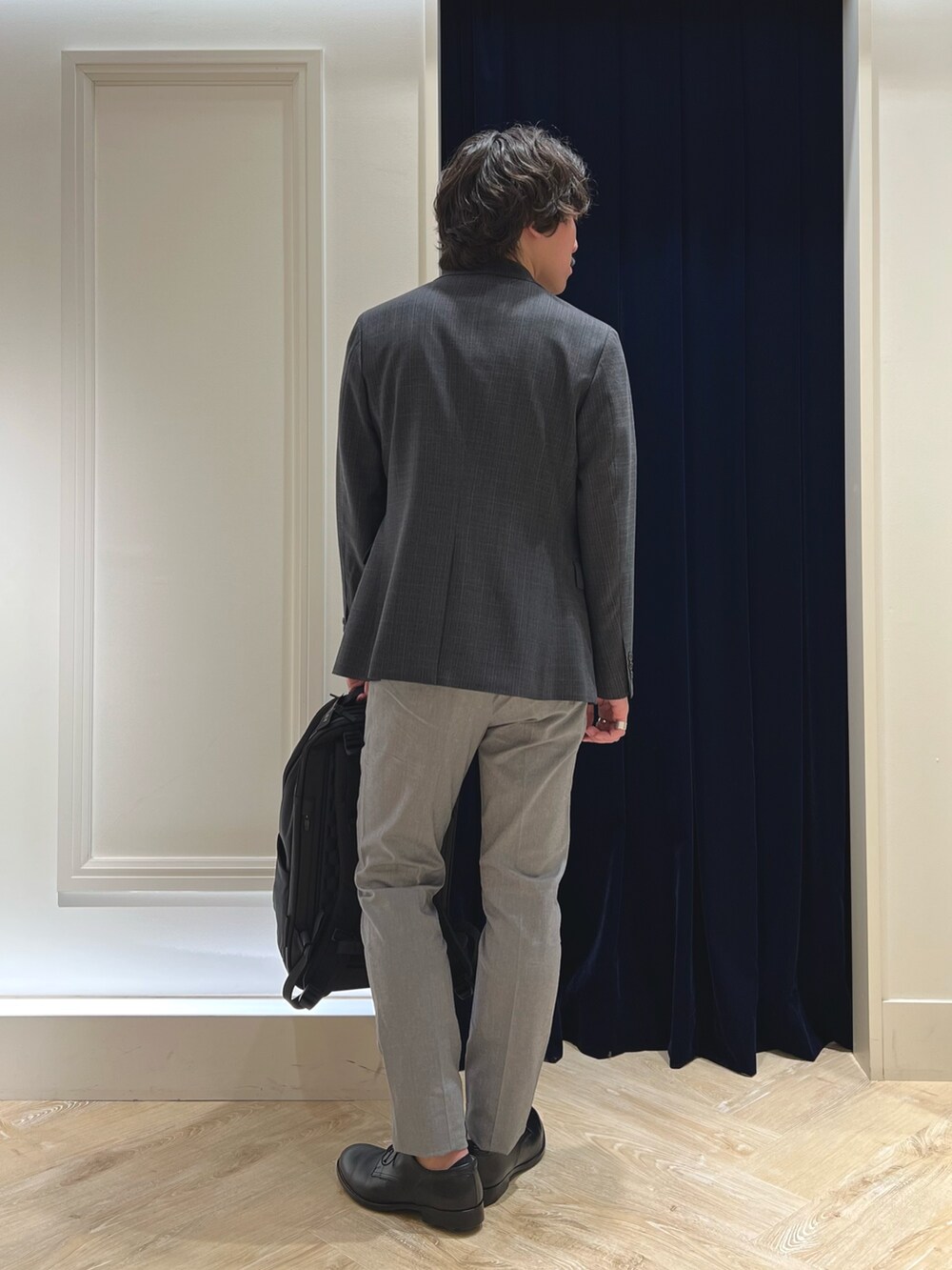 グレー系のテーラードジャケット、ホワイト系のTシャツ/カットソー、グレー系のチノパンツを着用したメンズの春コーディネートの7枚目の写真