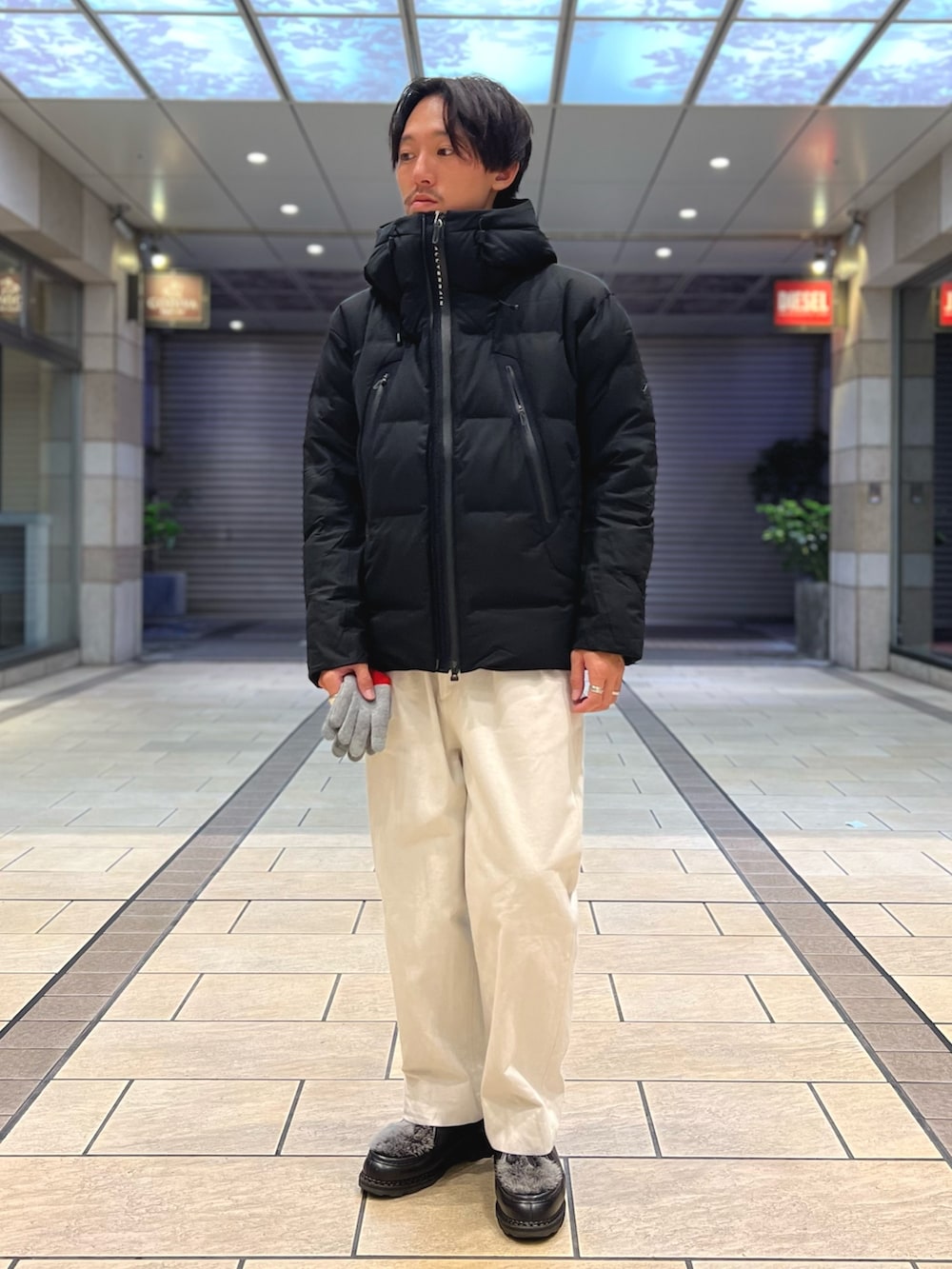 グレー系のスウェット、ブラック系のダウンジャケット/コート、グレー系の手袋を着用したメンズの秋コーディネートの2枚目の写真