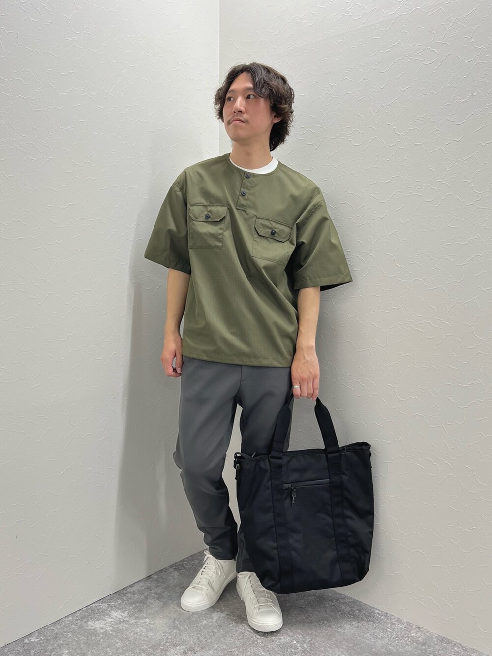 グリーン系のTシャツ/カットソー、ブラック系のトートバッグ、グレー系のその他パンツを着用したメンズの春コーディネートの4枚目の写真