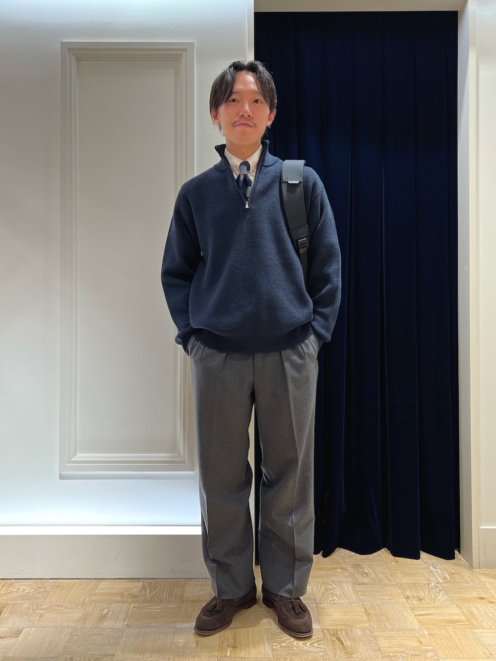 ブルー系のニット/セーター、ブルー系のネクタイ、ブラウン系のローファーを着用したメンズの冬コーディネートの2枚目の写真