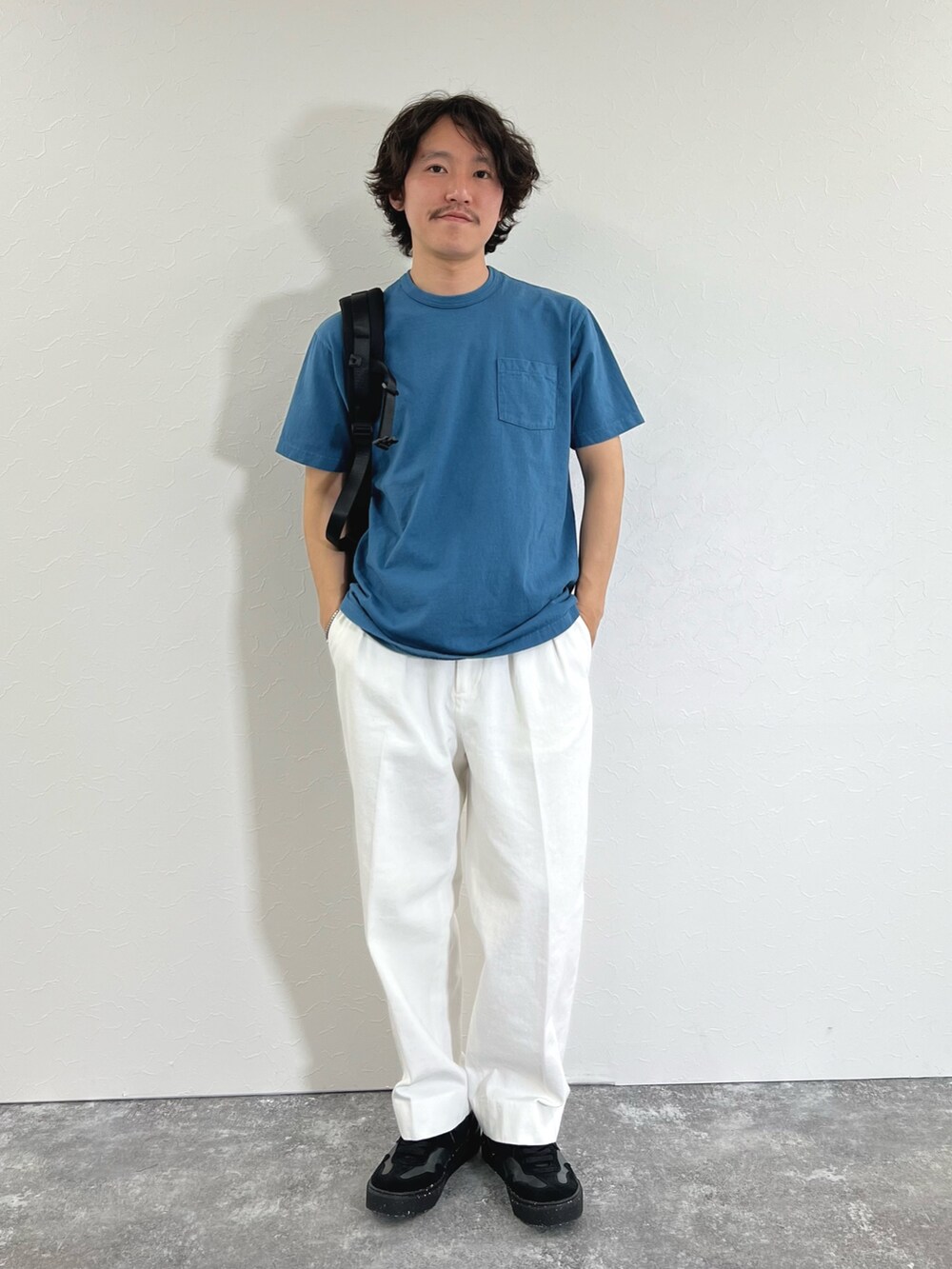 ブルー系のTシャツ/カットソー、ブラック系のショルダーバッグ、ホワイト系のデニムパンツを着用したメンズの春コーディネートの4枚目の写真