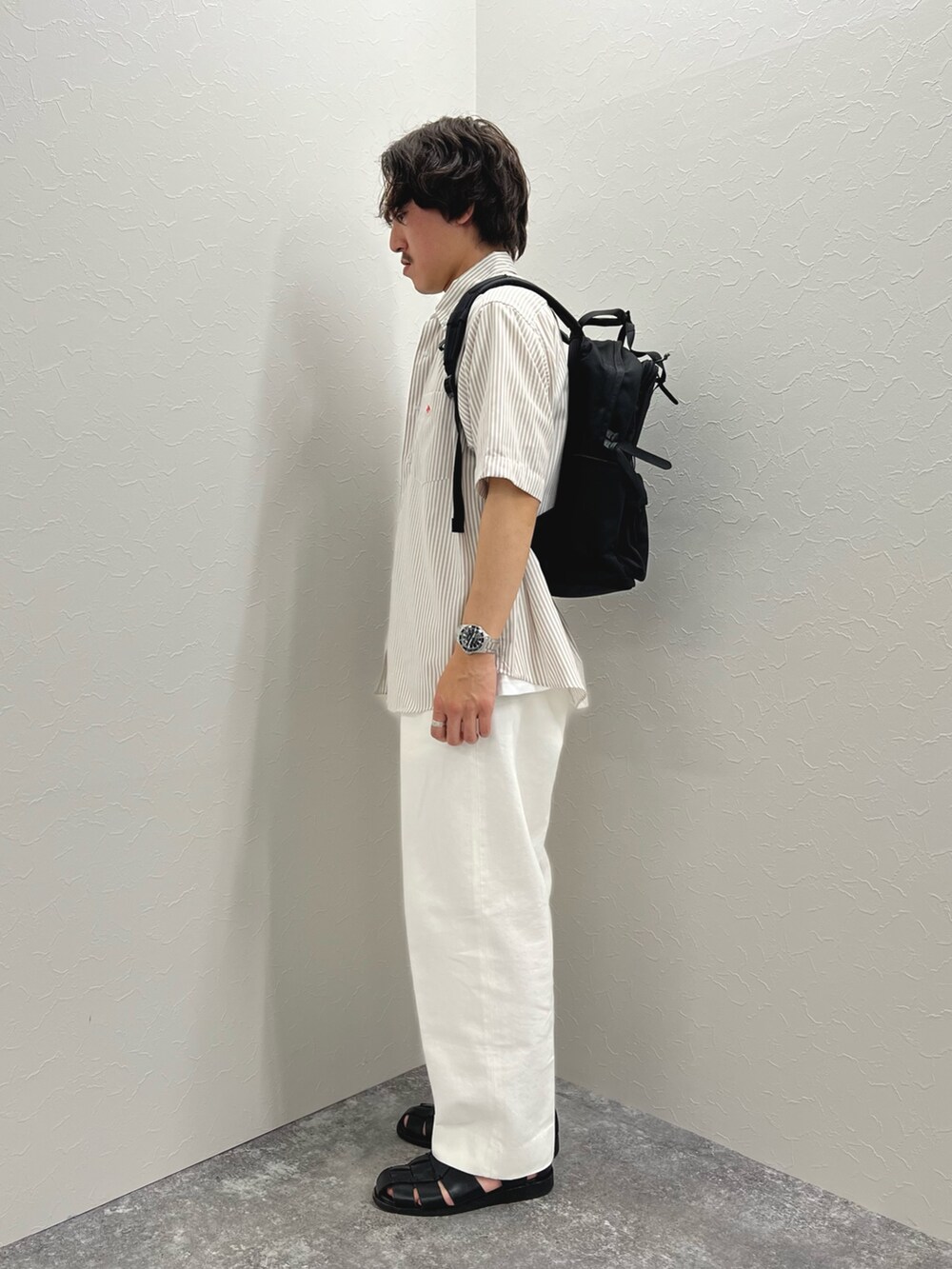 ホワイト系のTシャツ/カットソー、ブラック系のバックパック/リュック、ホワイト系のデニムパンツを着用したメンズの春コーディネートの7枚目の写真