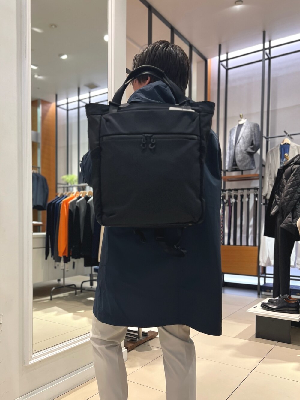 ブルー系のその他アウター、ブルー系のニット/セーター、ブラック系のトートバッグを着用したメンズの冬コーディネートの9枚目の写真