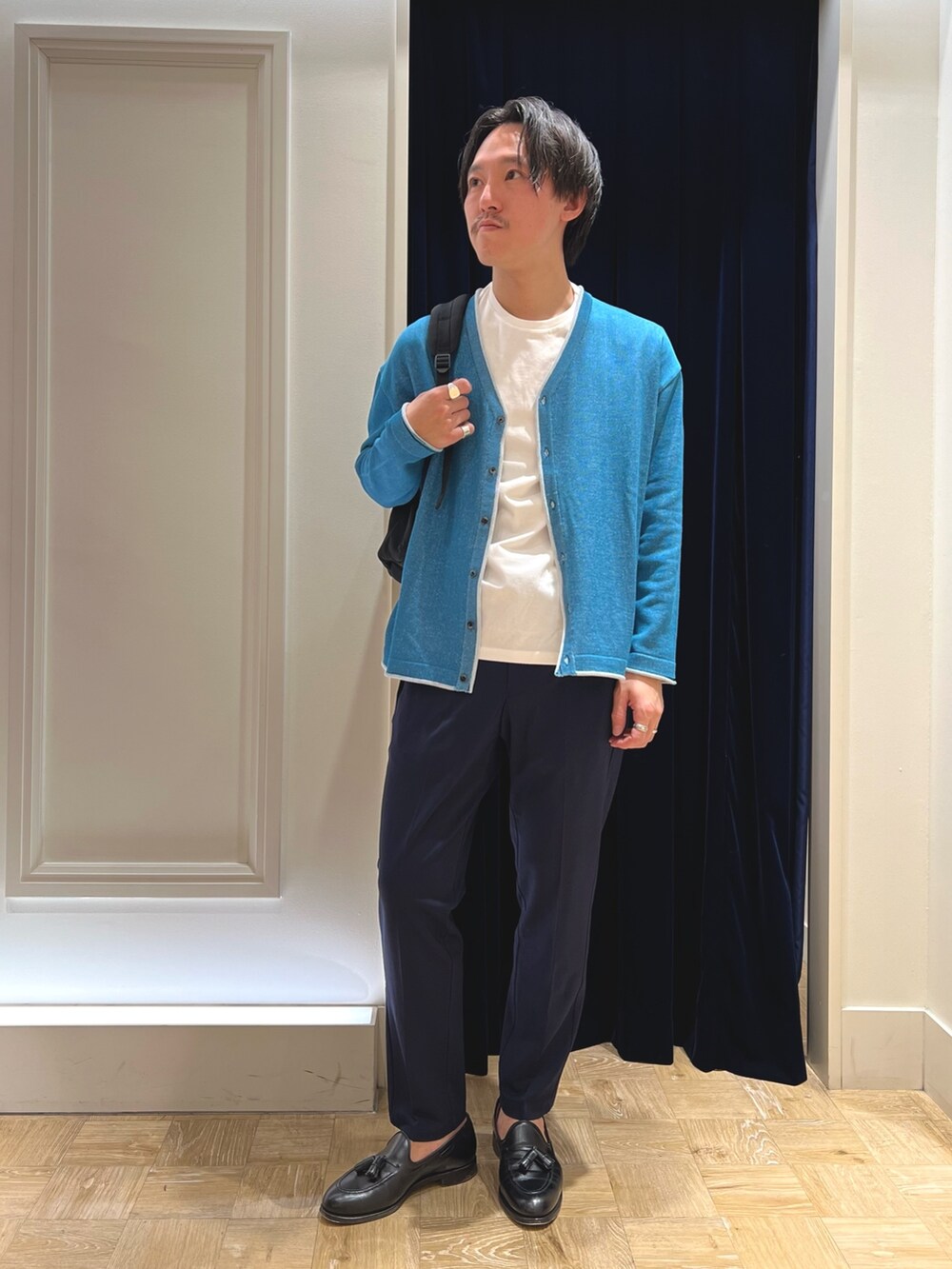 グリーン系のカーディガン/ボレロ、ブラック系のバックパック/リュックを着用したメンズの冬コーディネートの2枚目の写真