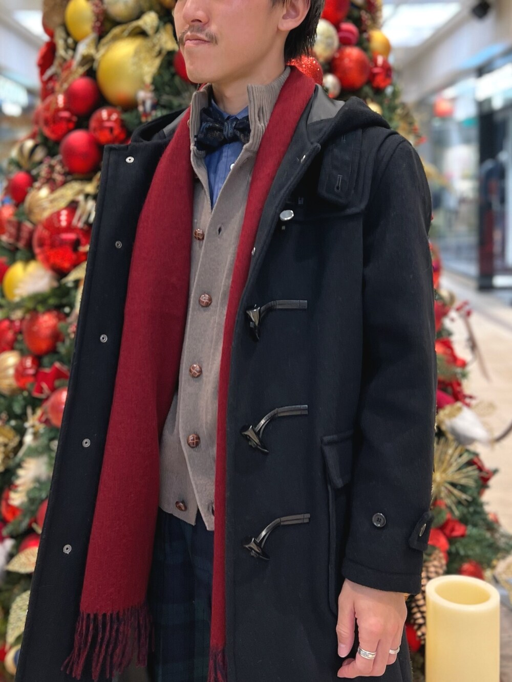 ベージュ系のカーディガン/ボレロ、ブラック系のダッフルコート、ブルー系のマフラーを着用したメンズの冬コーディネートの3枚目の写真