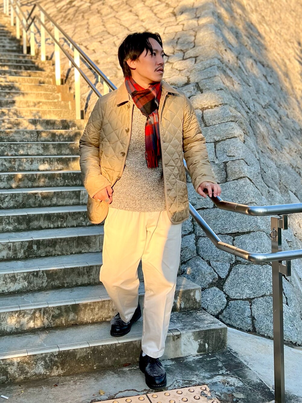 ベージュ系のブルゾン、ブルー系のマフラーを着用したメンズの秋コーディネートの6枚目の写真