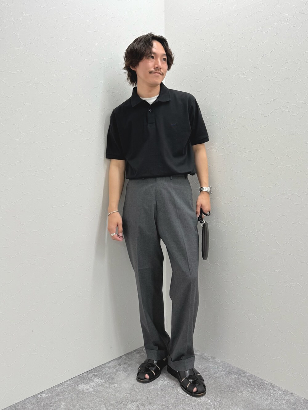 ブラック系のポロシャツ、ブラック系のショルダーバッグ、ブラック系のサンダルを着用したメンズの春コーディネートの3枚目の写真
