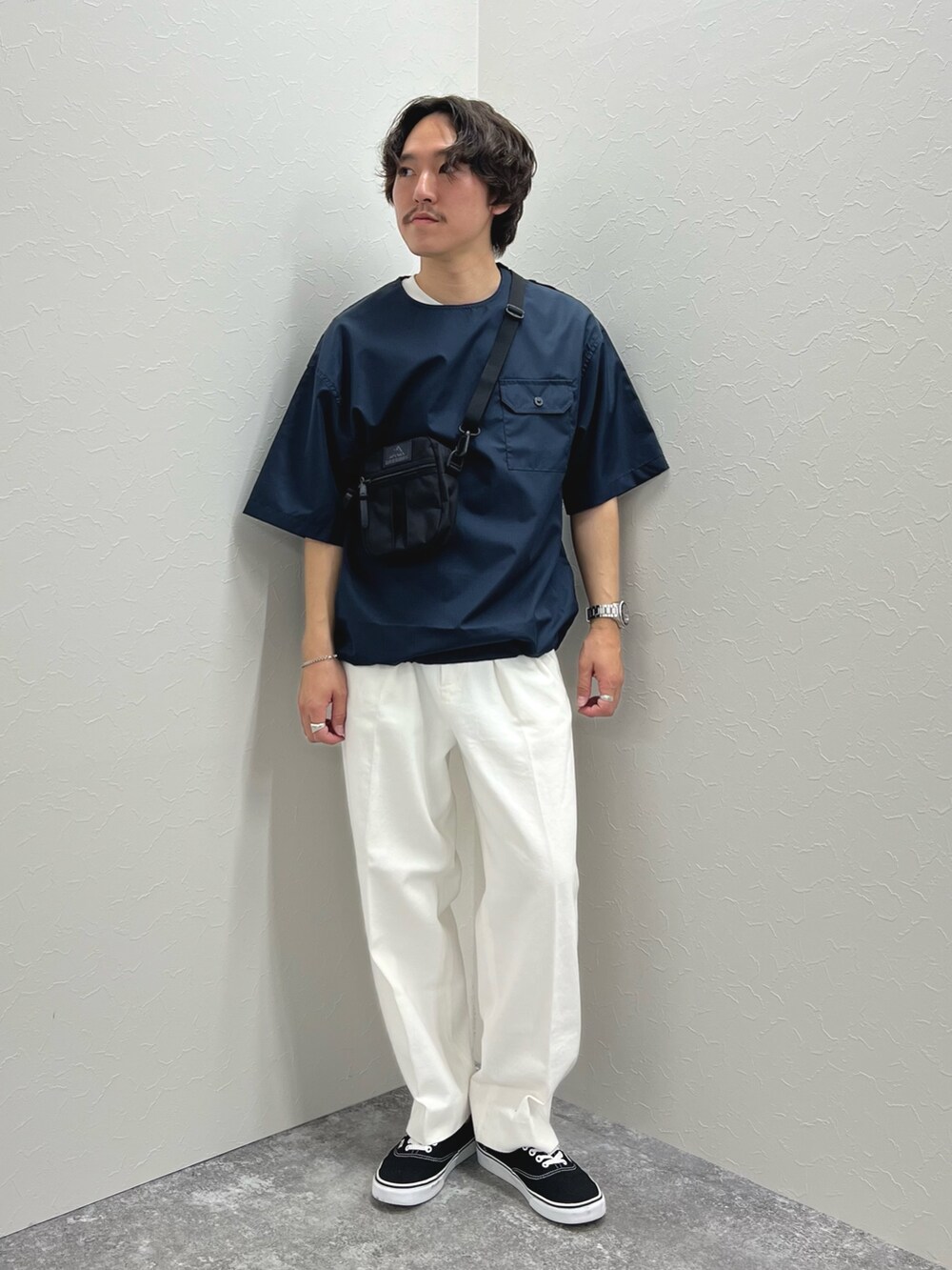ブルー系のTシャツ/カットソー、ブラック系のショルダーバッグ、ホワイト系のデニムパンツを着用したメンズの春コーディネートの2枚目の写真