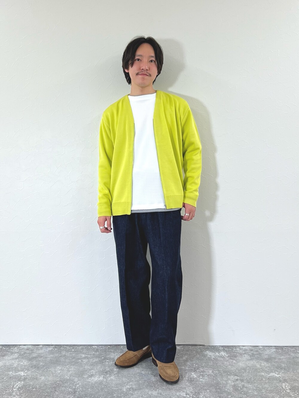 イエロー系のカーディガン/ボレロ、ホワイト系のTシャツ/カットソー、ブルー系のデニムパンツを着用したメンズの冬コーディネートの5枚目の写真