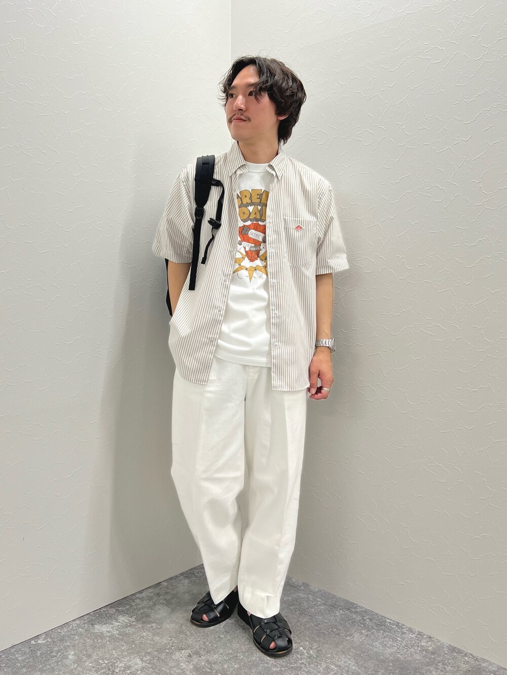 ホワイト系のTシャツ/カットソー、ブラック系のバックパック/リュック、ホワイト系のデニムパンツを着用したメンズの春コーディネートの2枚目の写真