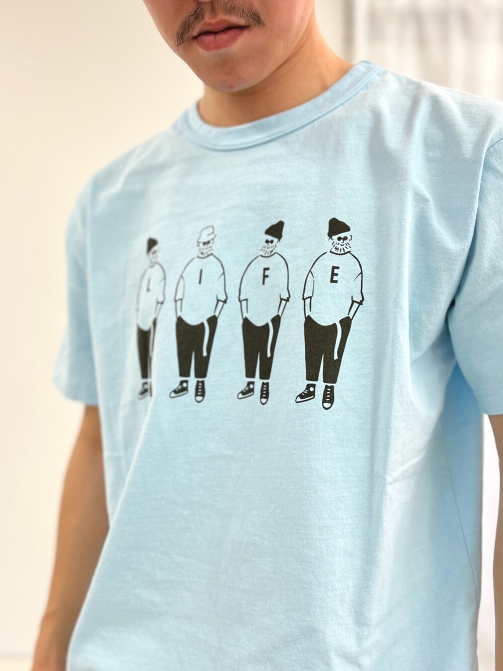 ブルー系のTシャツ/カットソー、ブラック系のその他パンツ、グレー系のトートバッグを着用したメンズの春コーディネートの5枚目の写真