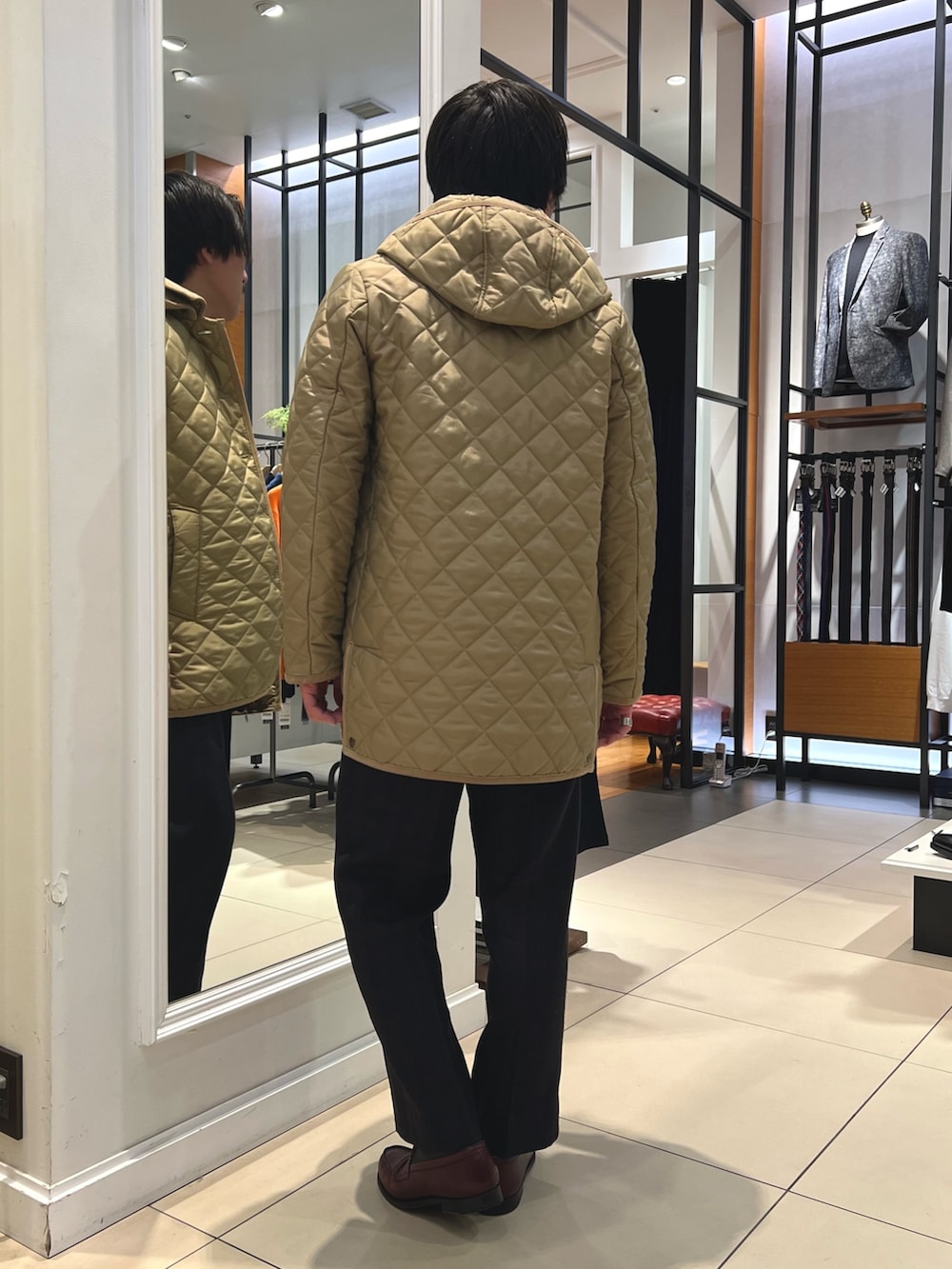 ベージュ系のブルゾン、ブルー系のテーラードジャケット、ブラウン系のローファーを着用したメンズの冬コーディネートの7枚目の写真