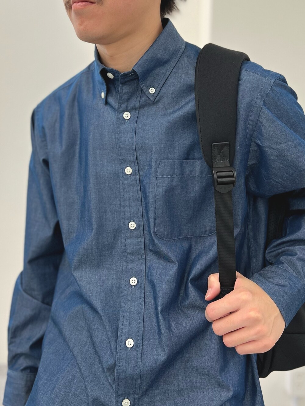 ブルー系のシャツ/ブラウス、ブラック系のバックパック/リュックを着用したメンズの春コーディネートの6枚目の写真