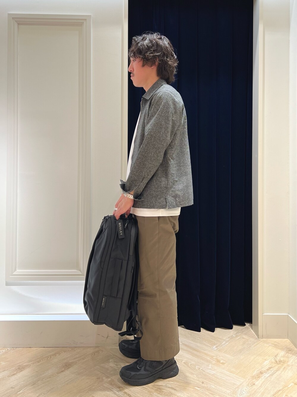 グレー系のブルゾン、ホワイト系のTシャツ/カットソー、ブラック系のバックパック/リュックを着用したメンズの春コーディネートの6枚目の写真