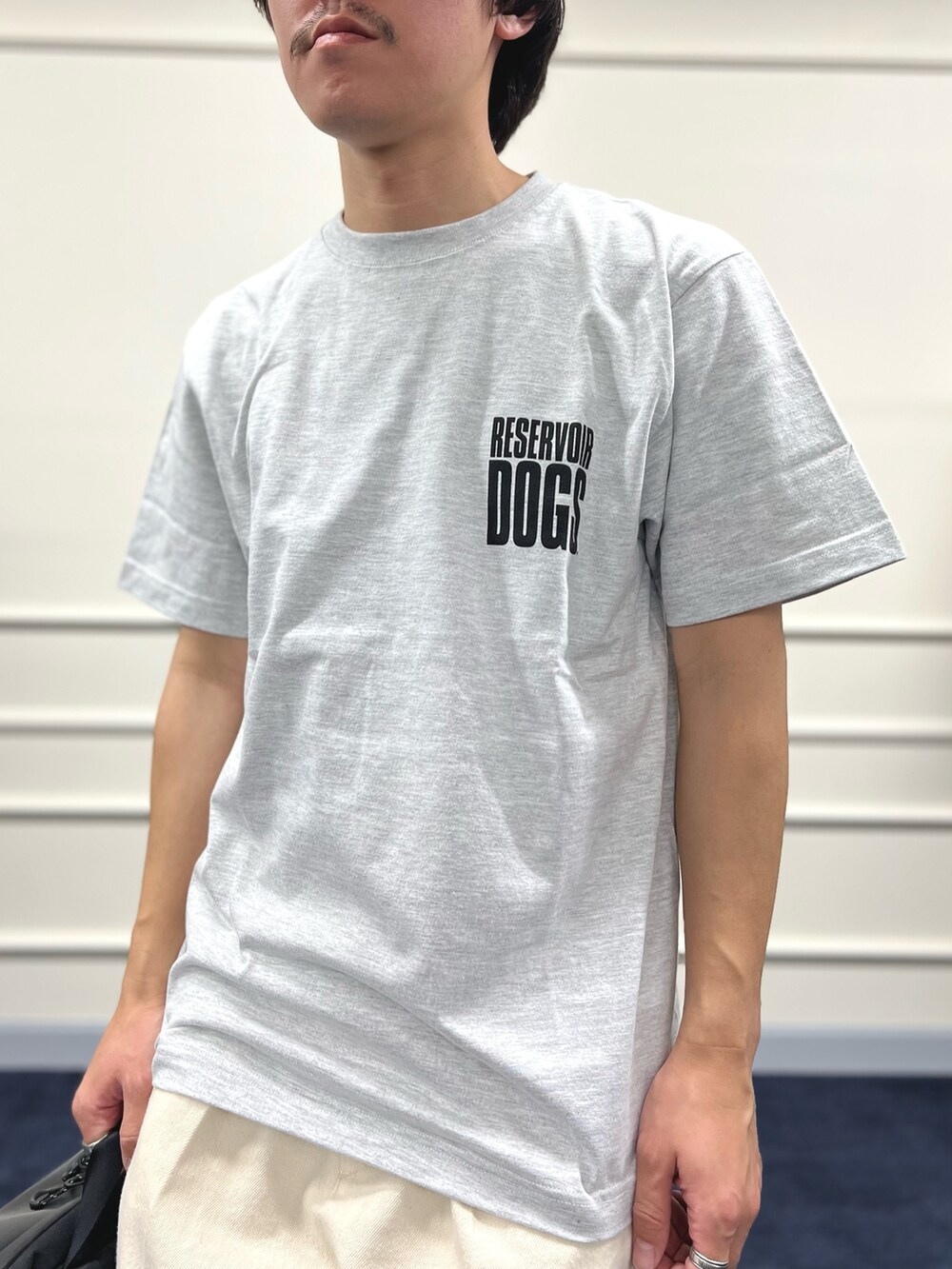 グレー系のTシャツ/カットソー、ブラック系のバックパック/リュック、ホワイト系のデニムパンツを着用したメンズの冬コーディネートの7枚目の写真