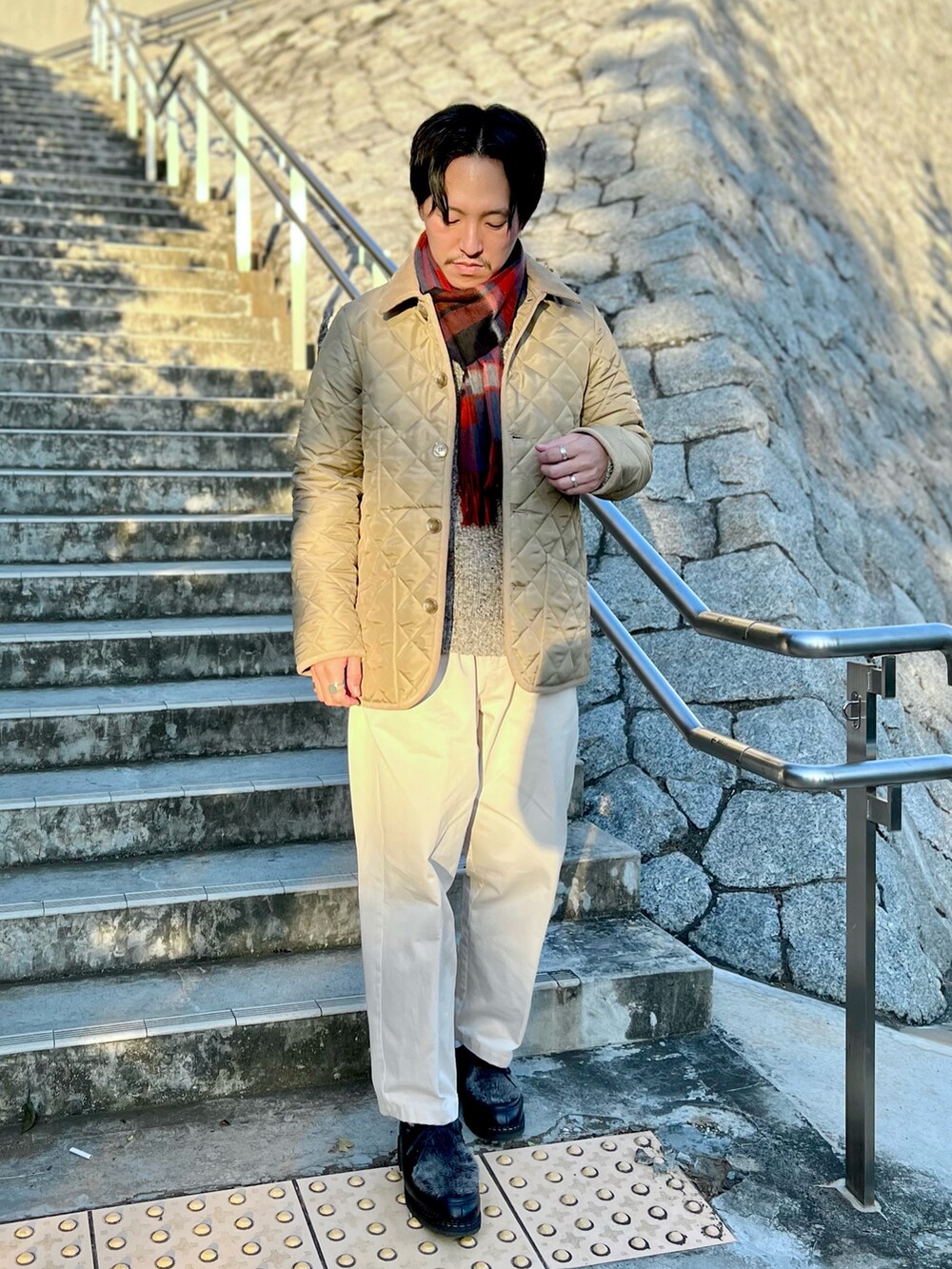 ベージュ系のブルゾン、ブルー系のマフラーを着用したメンズの秋コーディネートの3枚目の写真