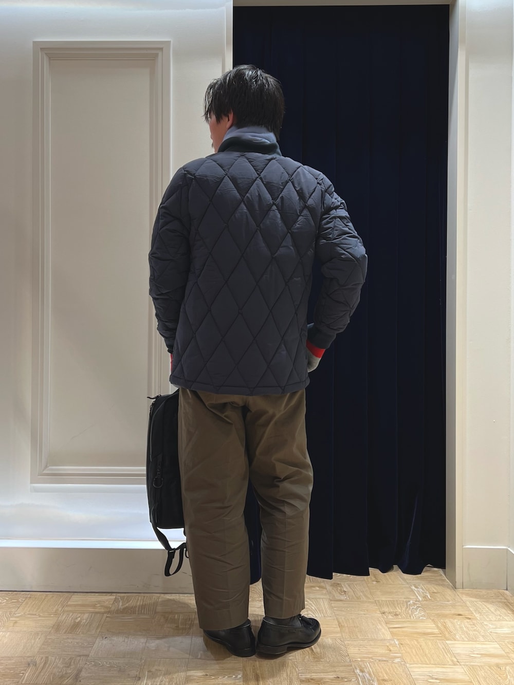 ブルー系のダウンジャケット/コート、ブラック系のバックパック/リュック、ブルー系のマフラーを着用したメンズの冬コーディネートの5枚目の写真