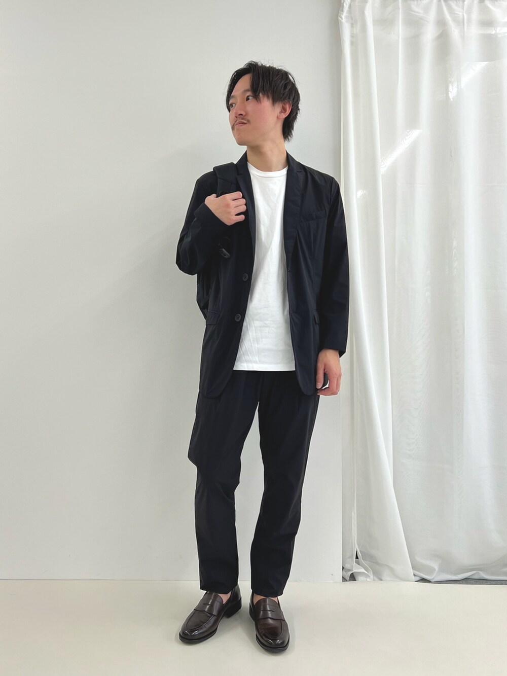 ブラック系のバックパック/リュック、ブルー系のテーラードジャケット、ブルー系のその他パンツを着用したメンズの夏コーディネートの2枚目の写真