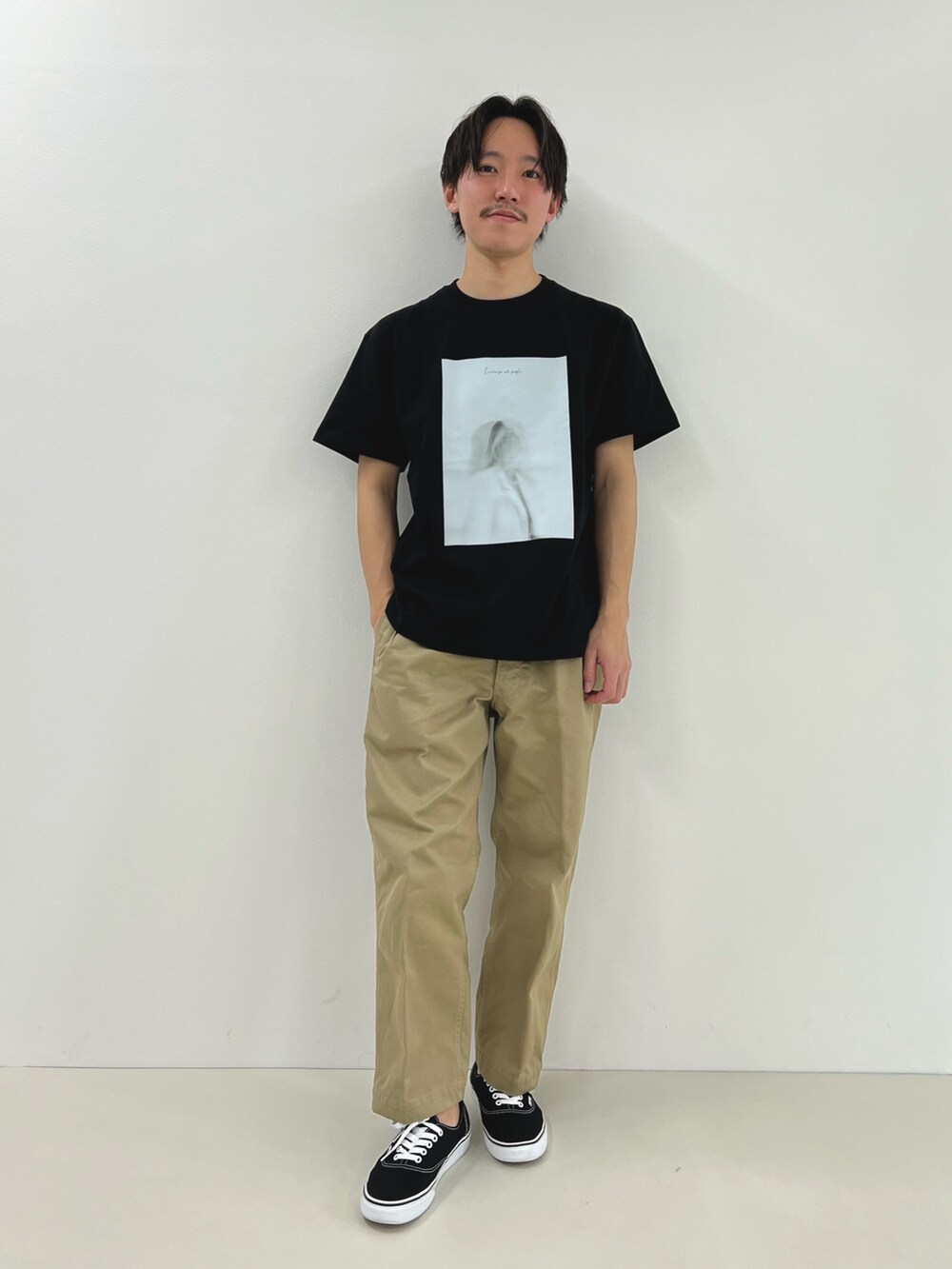 ブラック系のTシャツ/カットソーを着用したメンズの春コーディネートの2枚目の写真
