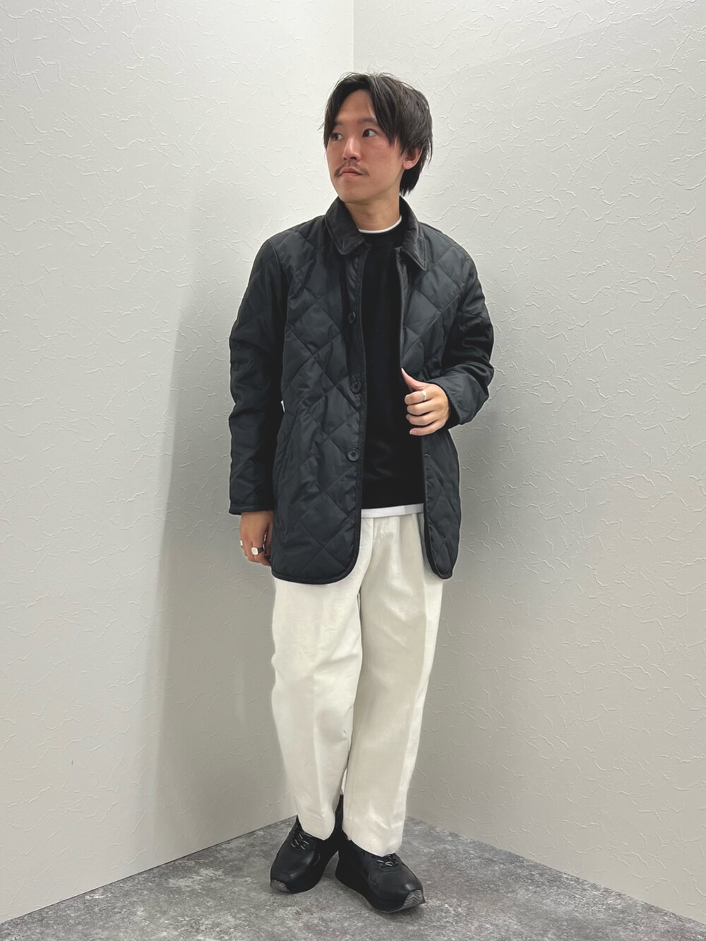 ブラック系のダウンジャケット/コート、ブラック系のTシャツ/カットソー、ブラック系のスニーカーを着用したメンズの秋コーディネートの2枚目の写真