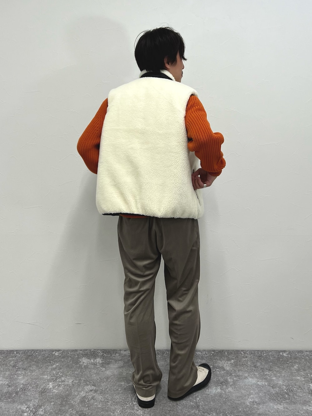 ホワイト系のダウンベスト、ベージュ系のその他パンツを着用したメンズの秋コーディネートの9枚目の写真