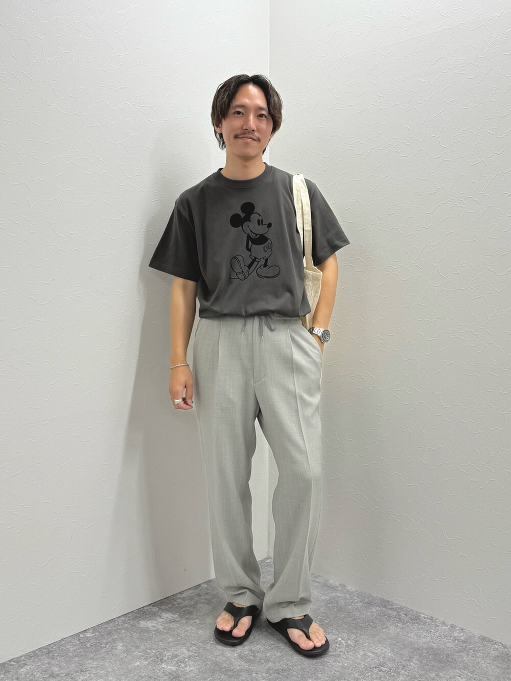 ブラック系のTシャツ/カットソー、ホワイト系のトートバッグ、ブラック系のサンダルを着用したメンズの夏コーディネートの4枚目の写真
