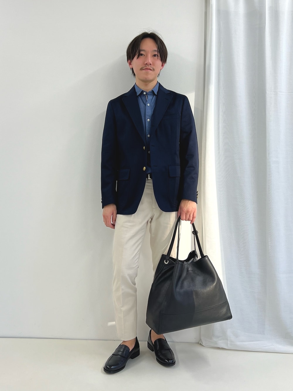 ブルー系のシャツ/ブラウス、ホワイト系のチノパンツ、ブラック系のローファーを着用したメンズの春コーディネートの6枚目の写真