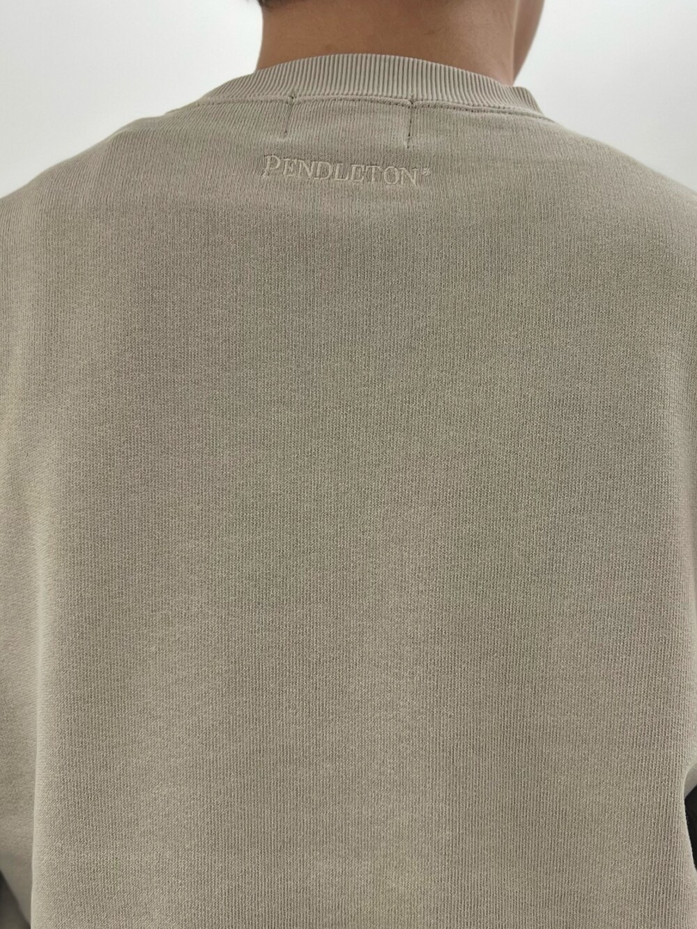 ベージュ系のスウェット、ブラック系のスニーカーを着用したメンズの秋コーディネートの7枚目の写真